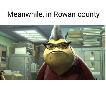Screencap of Roz from <em>Monster’s Inc.</em> Roz is a green slug-like creature with a mole, cat-eye glasses on a chain, and grey hair that stands straight up. Text at the top reads “Meanwhile, in Rowan county.”